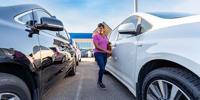 woman at CarMax location next to car